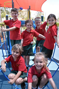 group of young students playing on the playground equipment