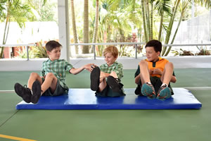 group of students exercising on a floor mat